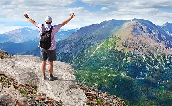 Man standing at a mountainous overlook. Take your checking to new heights.