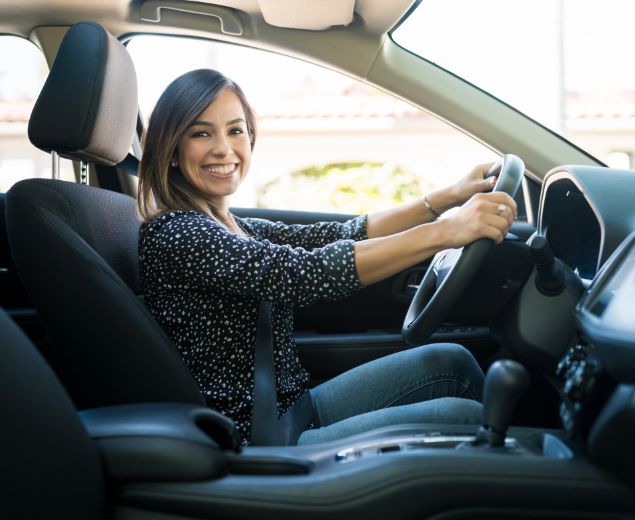 woman smiling in her new car image woman smiling in her new car image