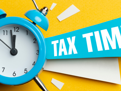 Image of a blue old-timey alarm clock on a bright yellow background with a TAX TIME banner
