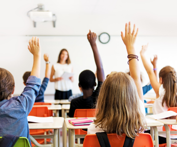 1 students raising hands in a classroom