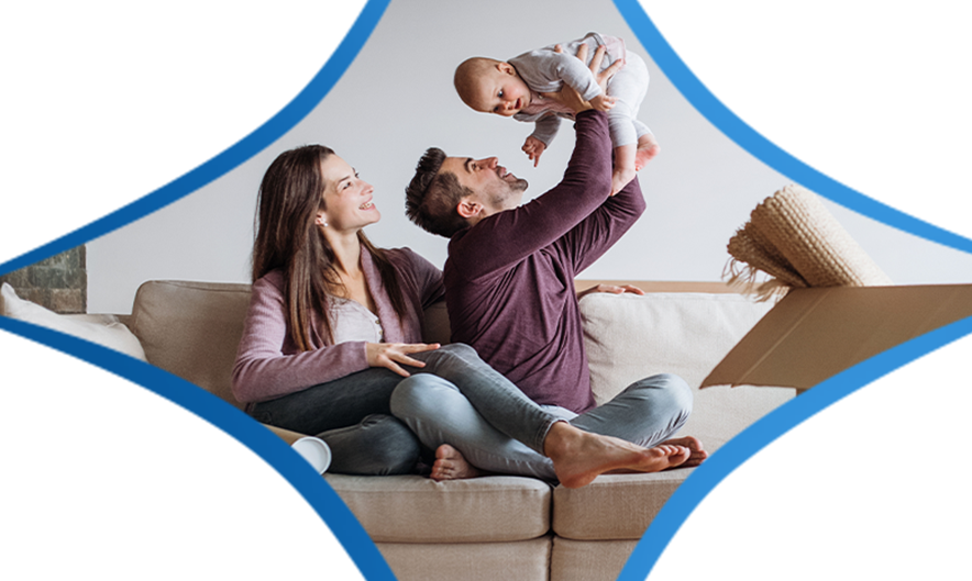 Husband and Wife holding baby on a couch