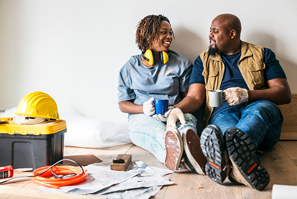 Home Equity Line of Credit at SCU Two people taking a break from construction on their house drinking a cup of coffee.
