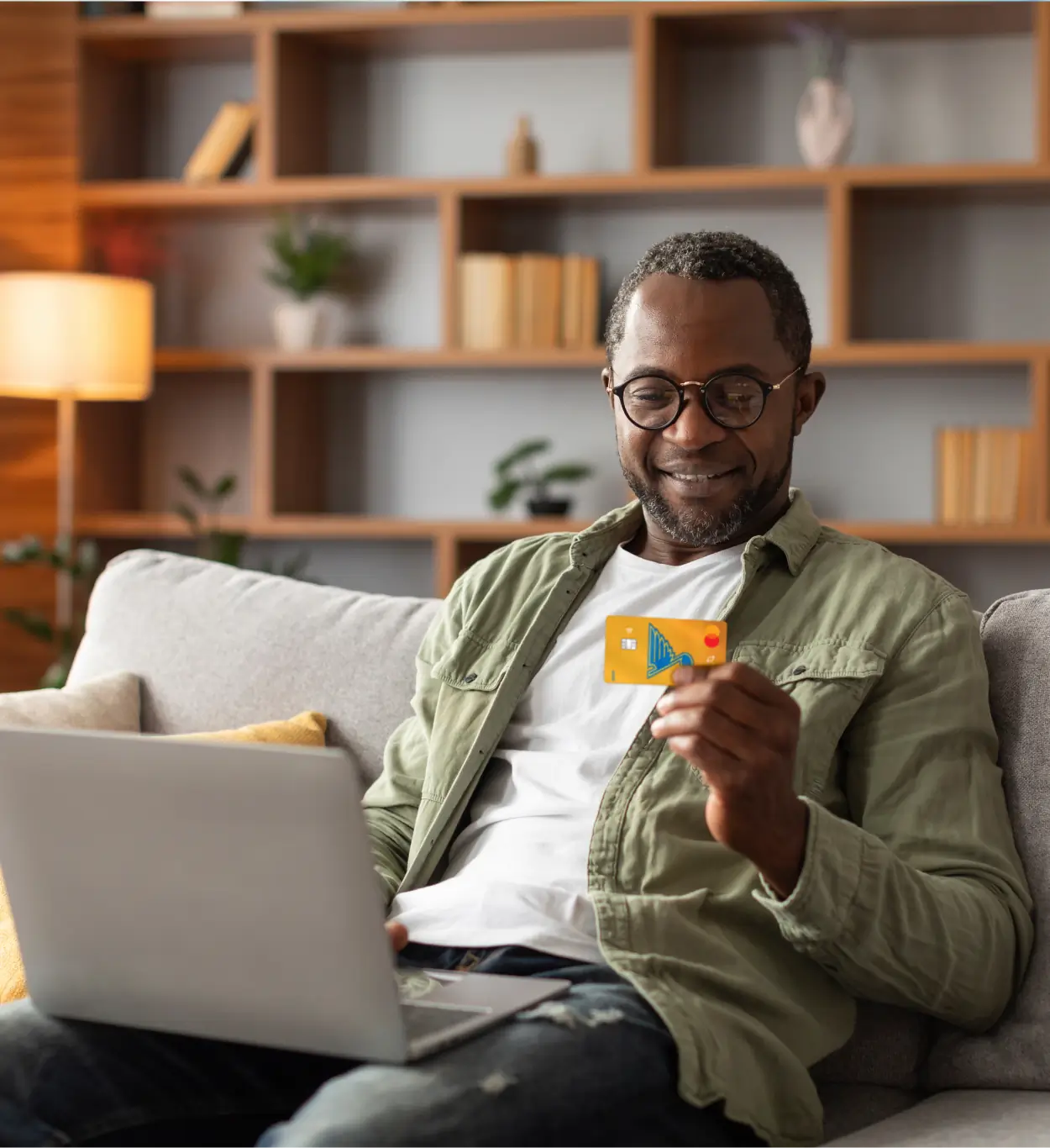 man smiling while holding debit card - Scott Credit Union man smiling while holding debit card